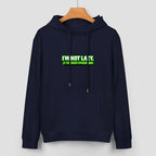 Sweatshirt escura com capuz e inscrição verde I’m Not Lazy, I’m Energy Efficient, num cabide.