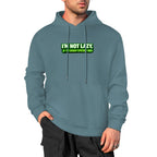 Sweatshirt cinzento-ardósia com capuz e inscrição verde I’m Not Lazy, I’m Energy Efficient, usada por um modelo.
